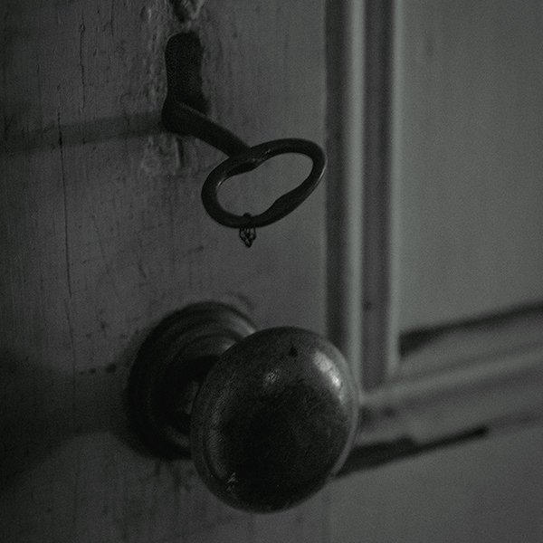 An antique doorknob and key inside an abandoned house.