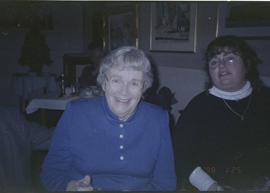 An elderly woman in a blue dress at a birthday party in the 1990's