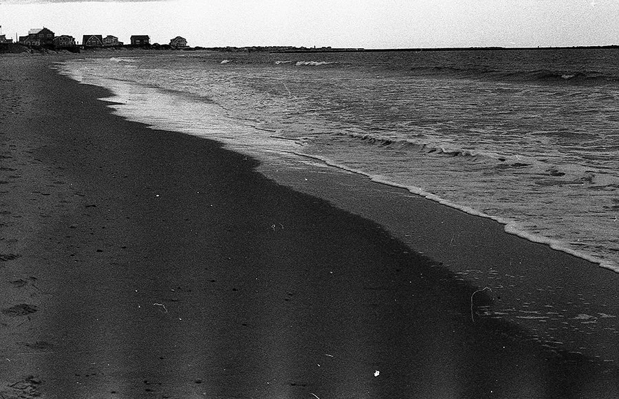 a black and white photograph of East Matunuck State Beach, facing the breachway at Galilee