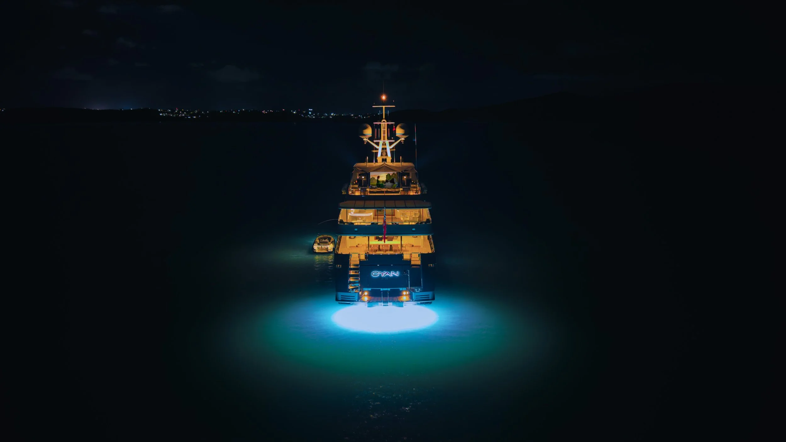 Luxury yacht at night with underwater lights glowing