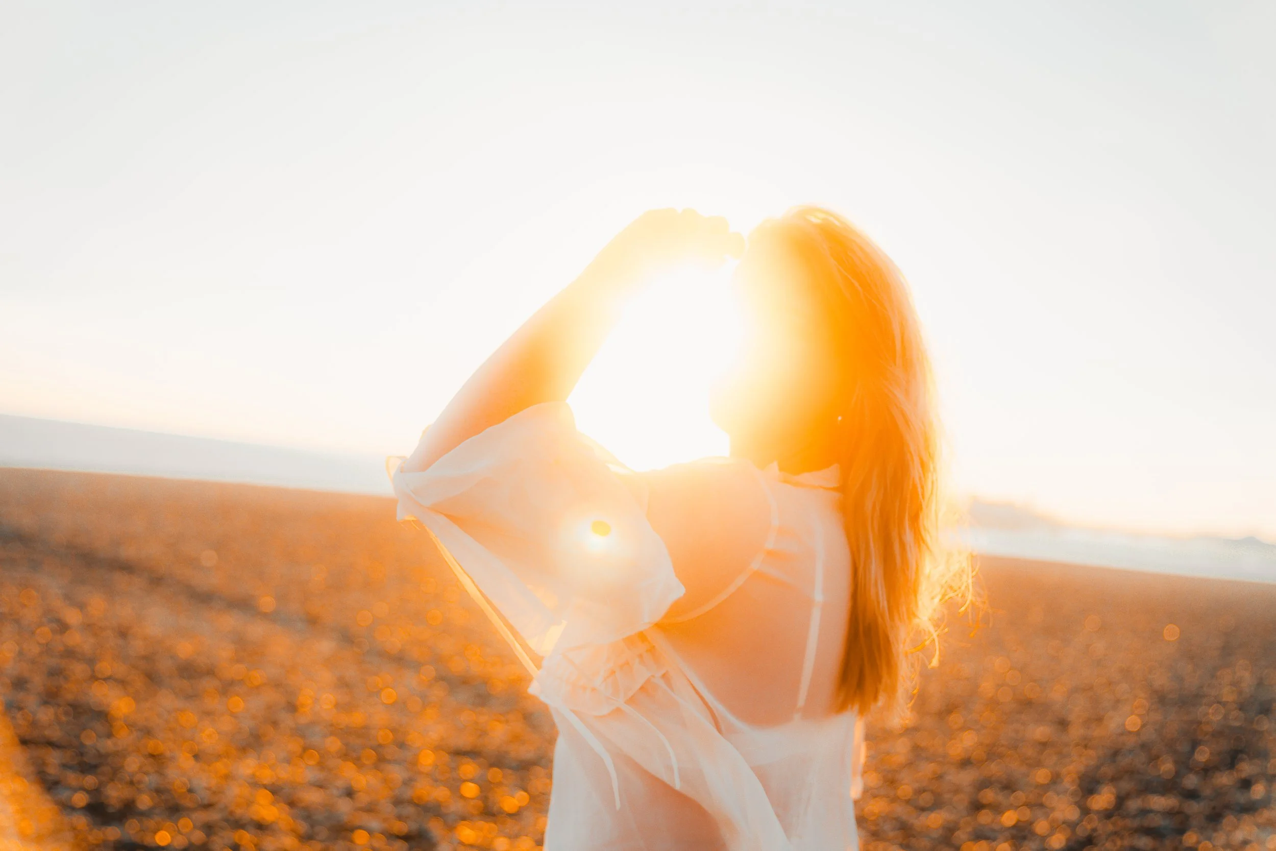 Person on beach with sunflare