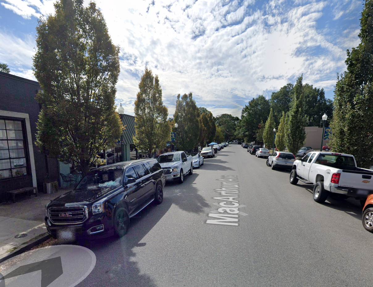 Deep tissue massage therapist Richmond VA. A street view of Main Street in a small town with parked cars on both sides, trees, and a partly cloudy sky overhead.