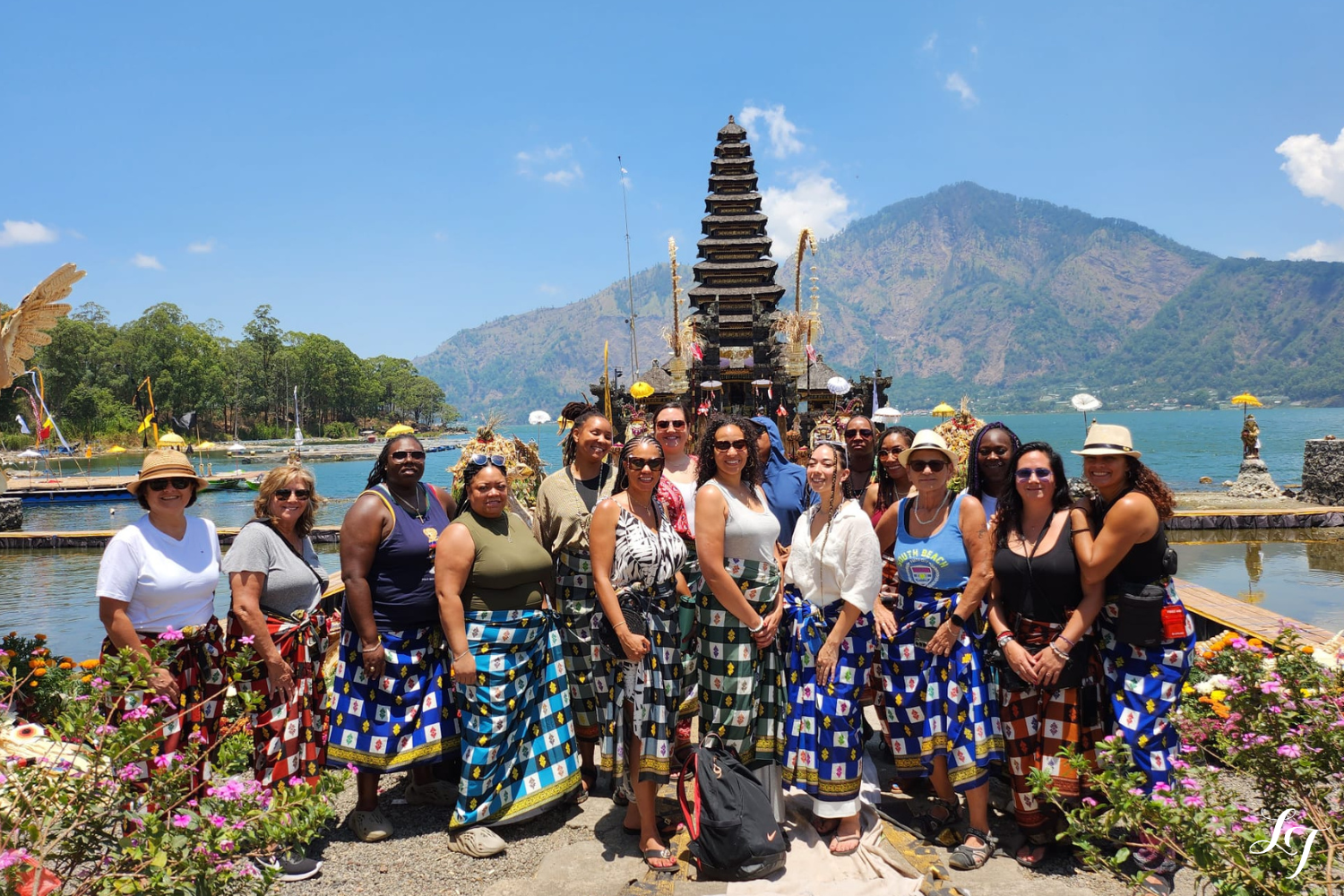 Queer women travelers at Ulun Danu Beratan Temple in Bali with lake and mountain view.