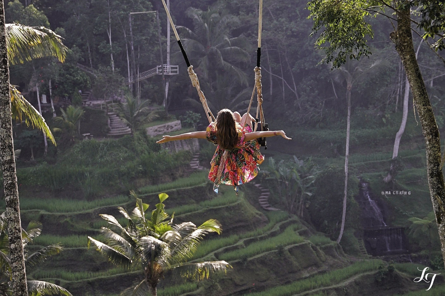 Traveler on Bali swing over lush rice terraces in Ubud, Indonesia.