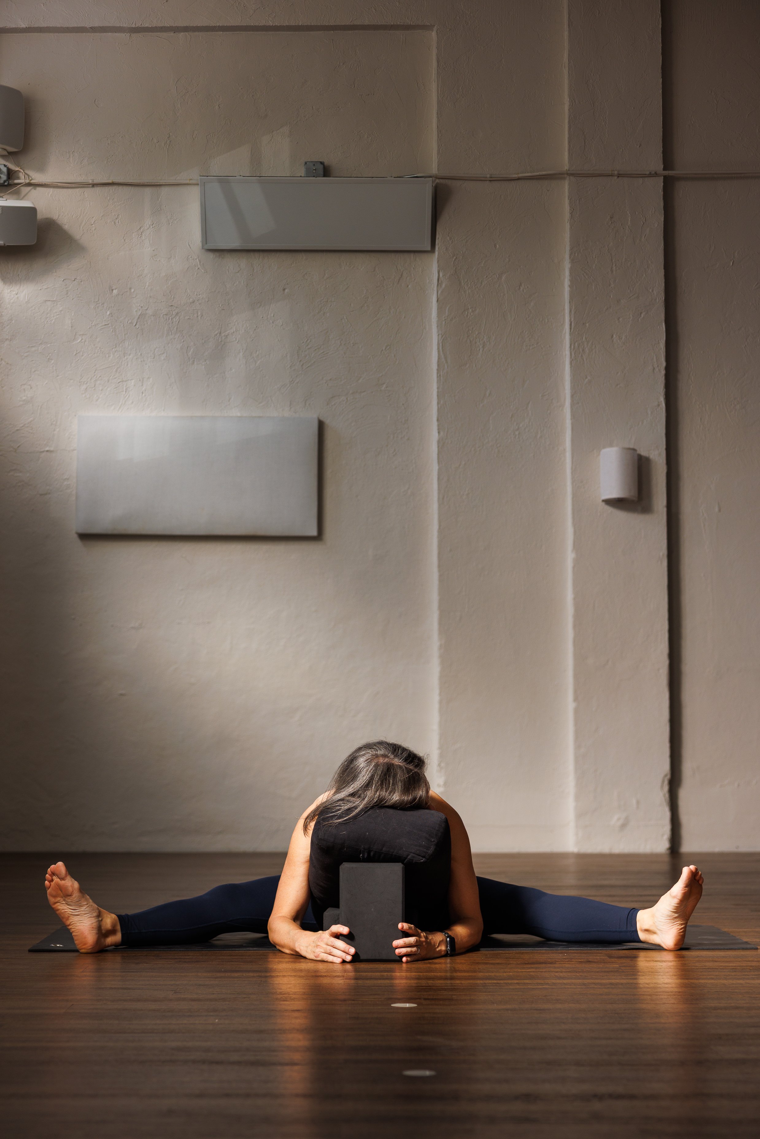 Person practicing yoga in a standing pose on a mat.