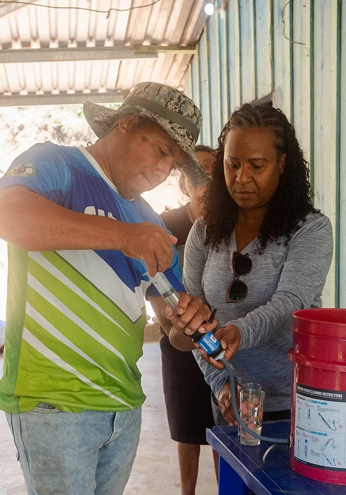 A Serve Hope team member teaching a woman how to use and maintain an Agua Pura water filter.