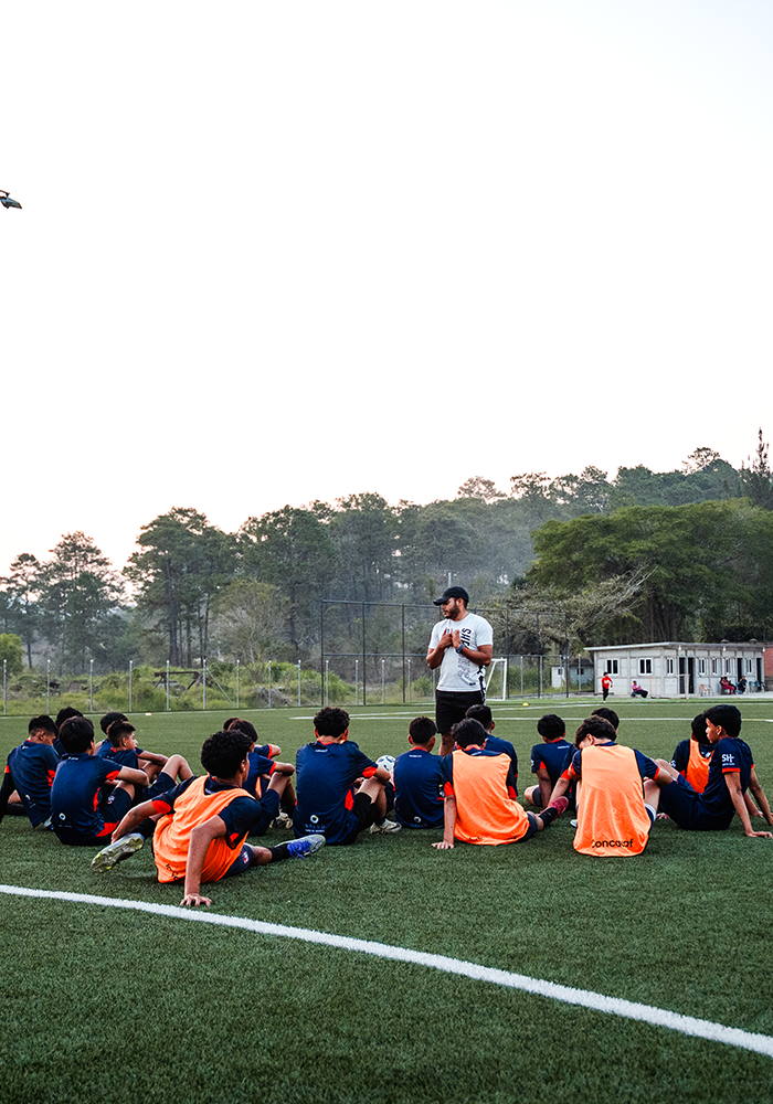 Serve Hope FC coach leading young soccer players in a team devotional in Honduras