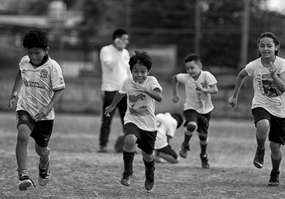 Children playing soccer in a community in Honduras, highlighting the passion for the game