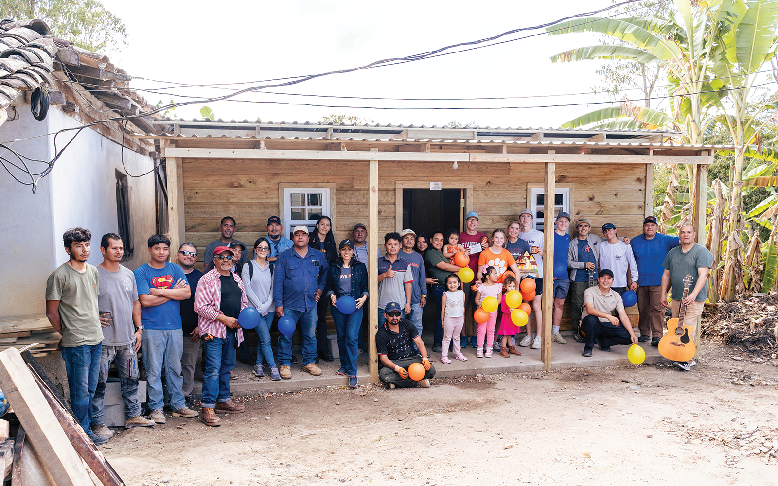 Serve Hope volunteers, local workers, and a Honduran family celebrate the completion of a newly built home through The Carpenter Project.