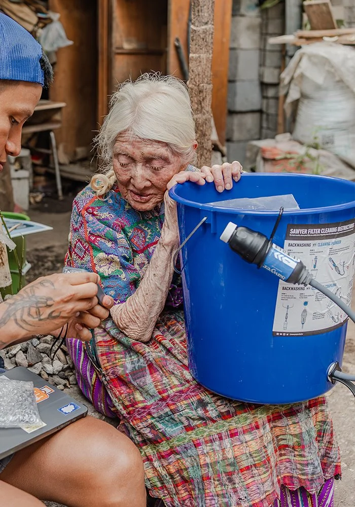 An older woman receiving an Agua Pura water filtration system during a Serve Hope distribution.