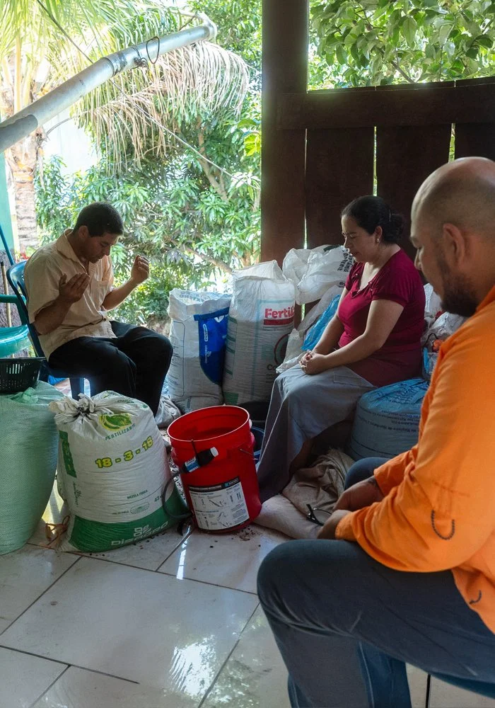 Local church leaders praying with a family during an Agua Pura water filter follow-up visit.