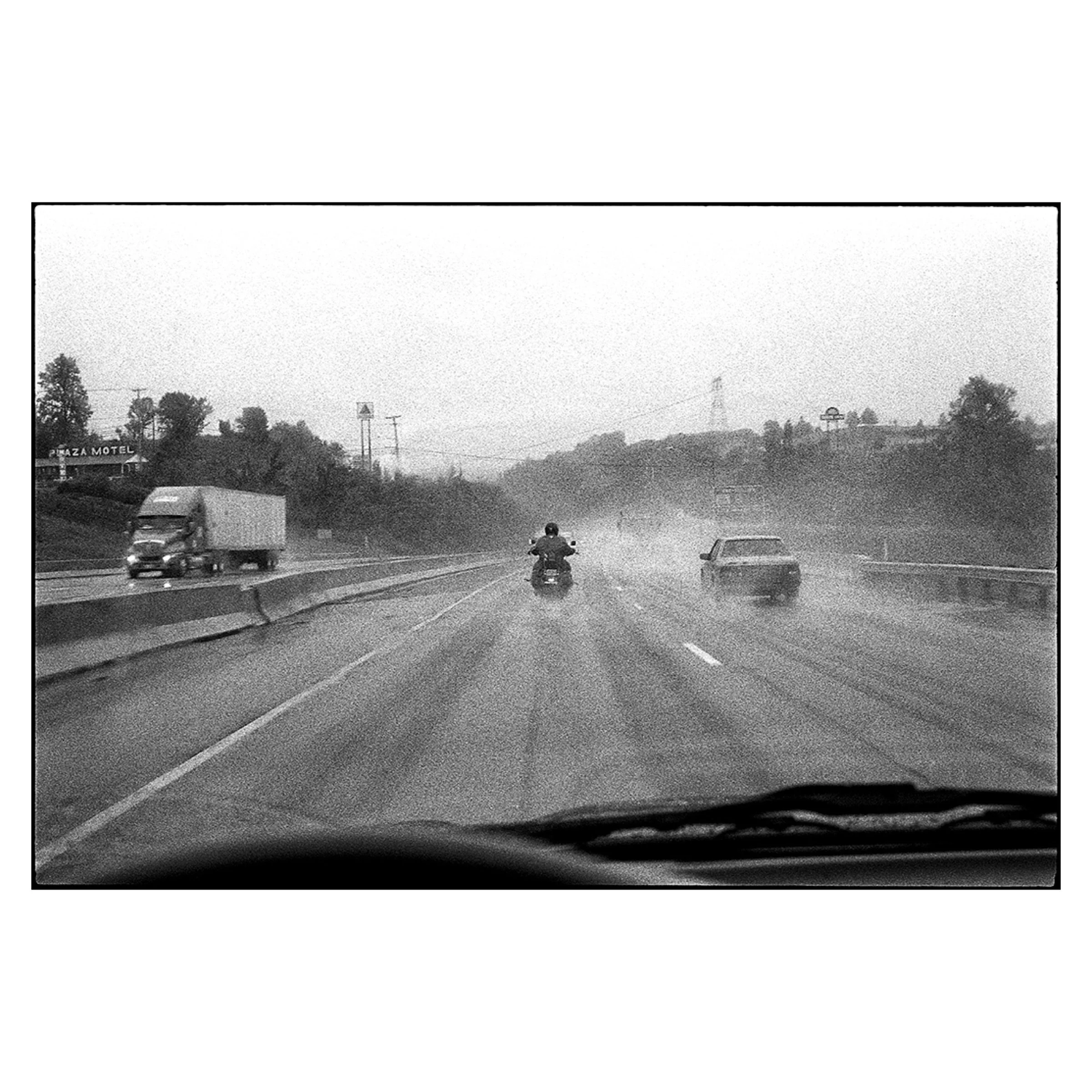 A lone rider in the rain, Highway 401, Ontario, 2001 © Dave Green