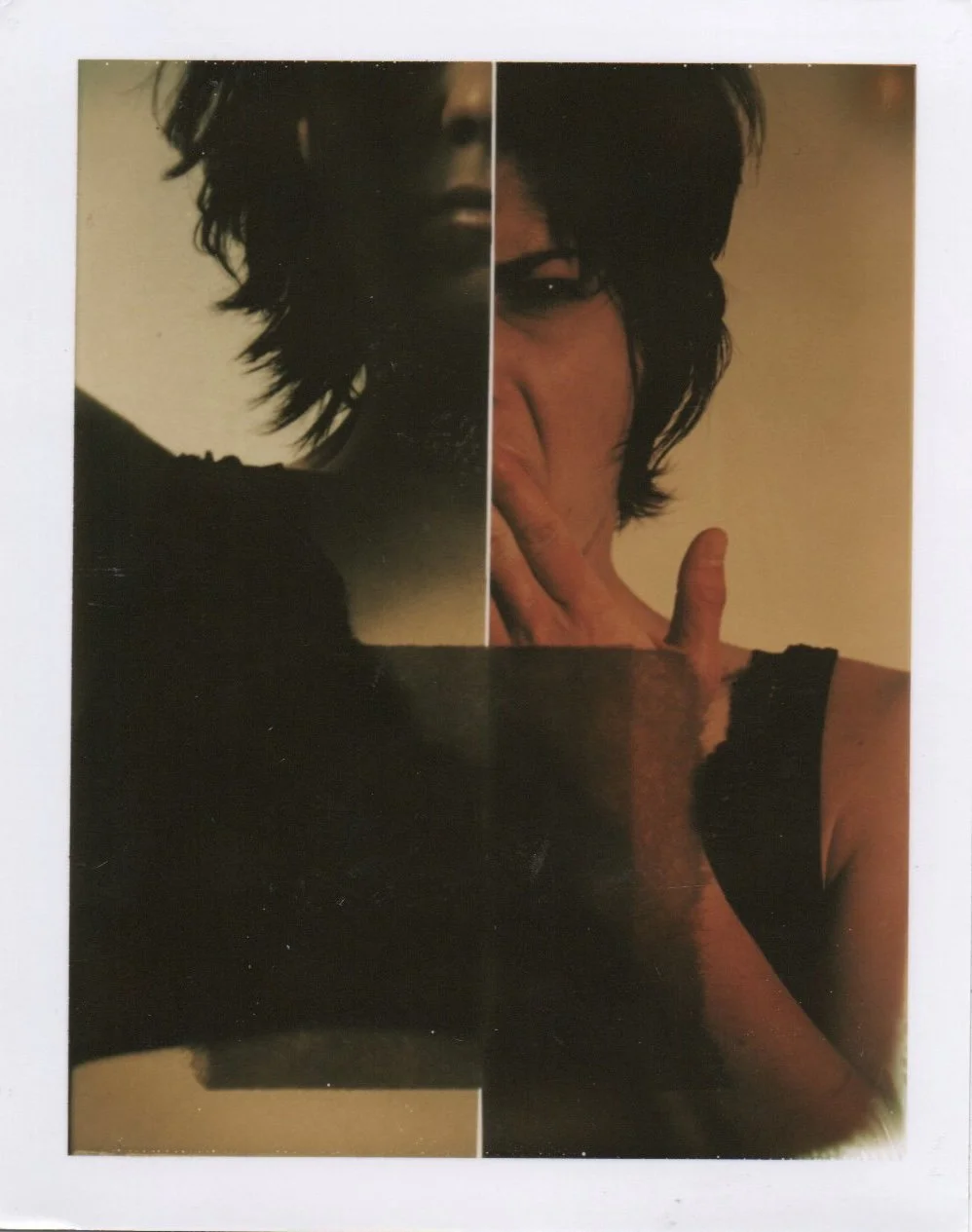 A composite of two portraits of a woman with short dark hair, one in shadow and the other with her hand touching her lips, wearing a black top.