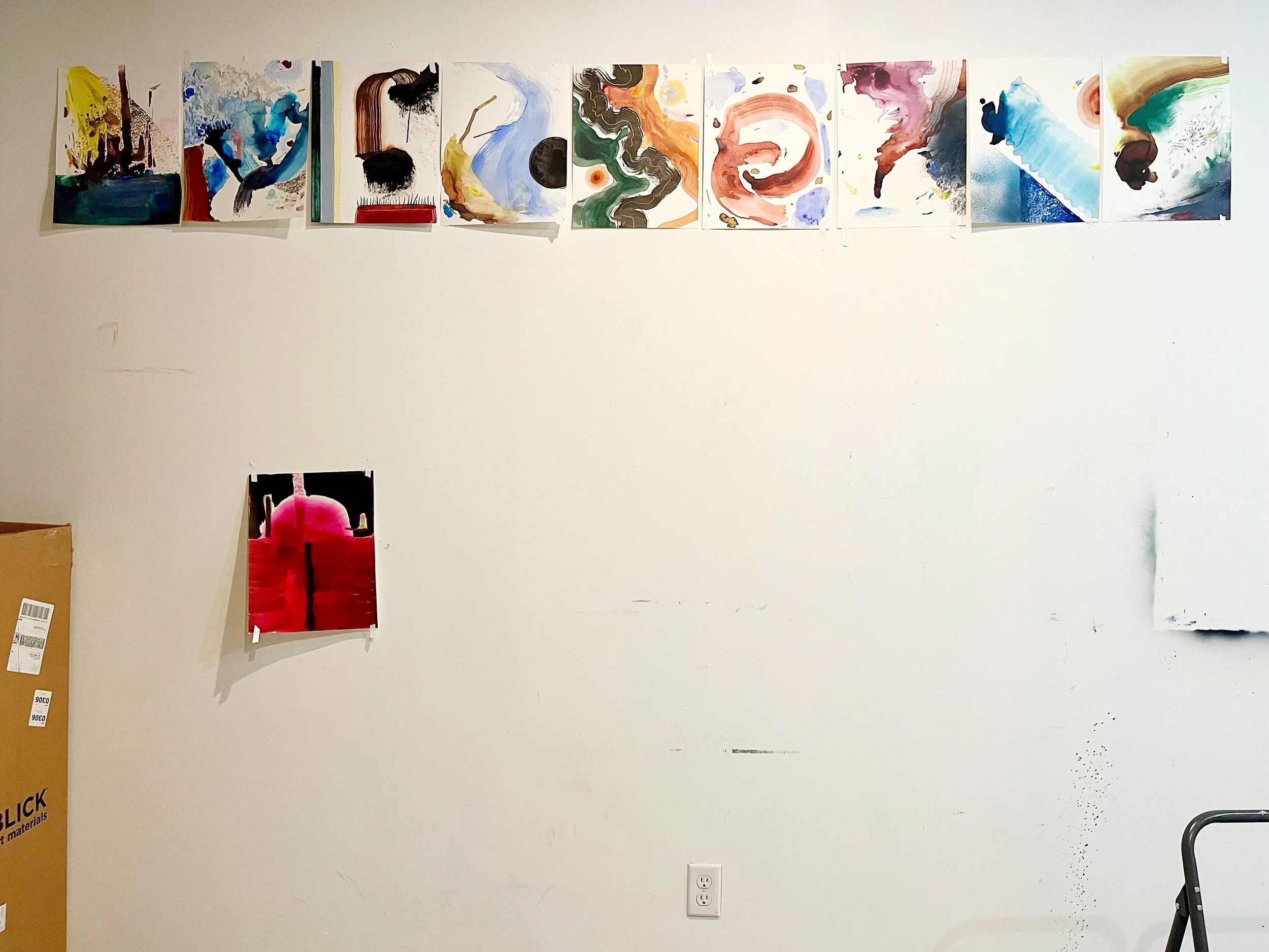 A wall displaying ten abstract paintings with various colors and brushstrokes, hung in a row in an art gallery.