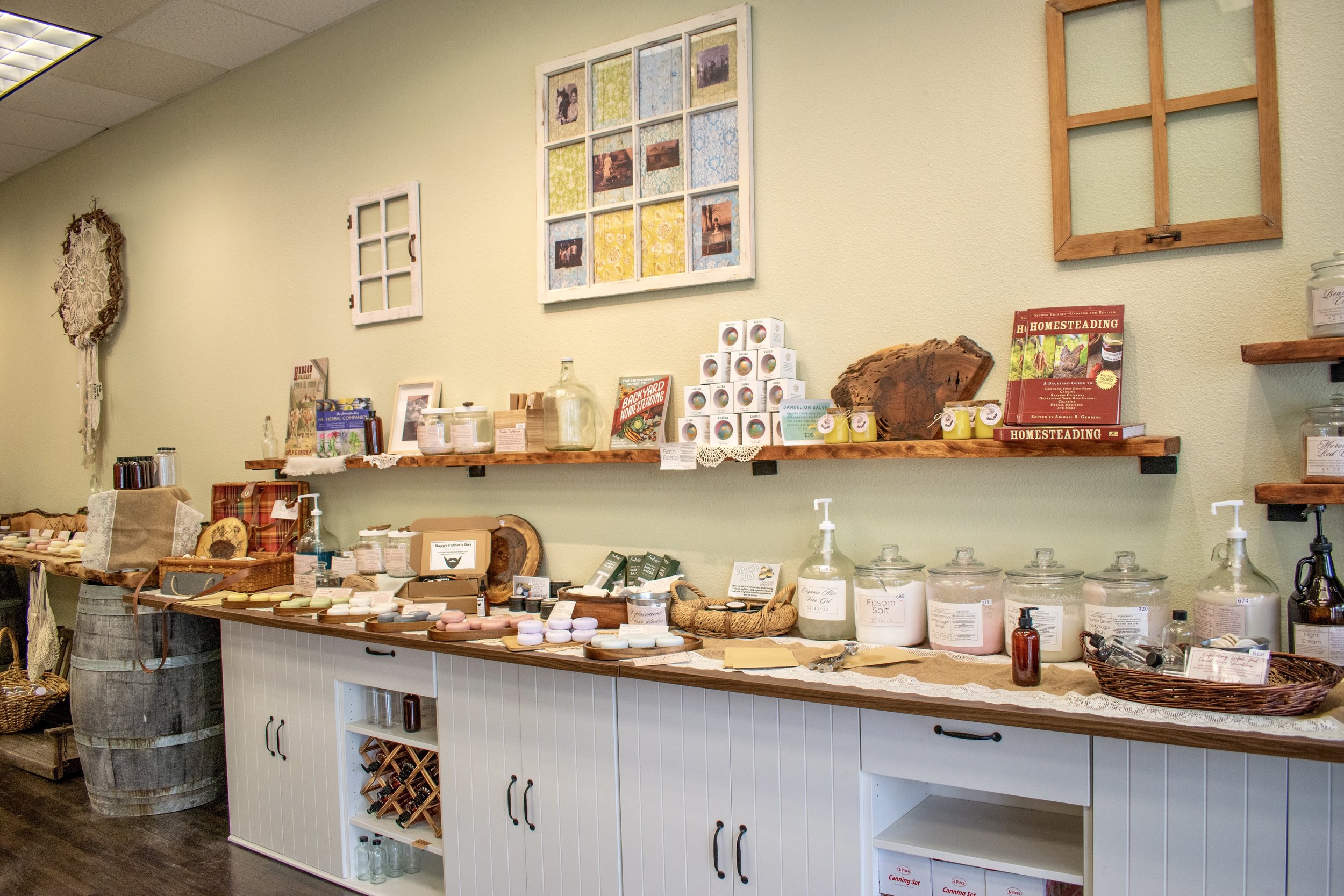 Display of homemade soap and natural health products on a wooden shelf in a store.