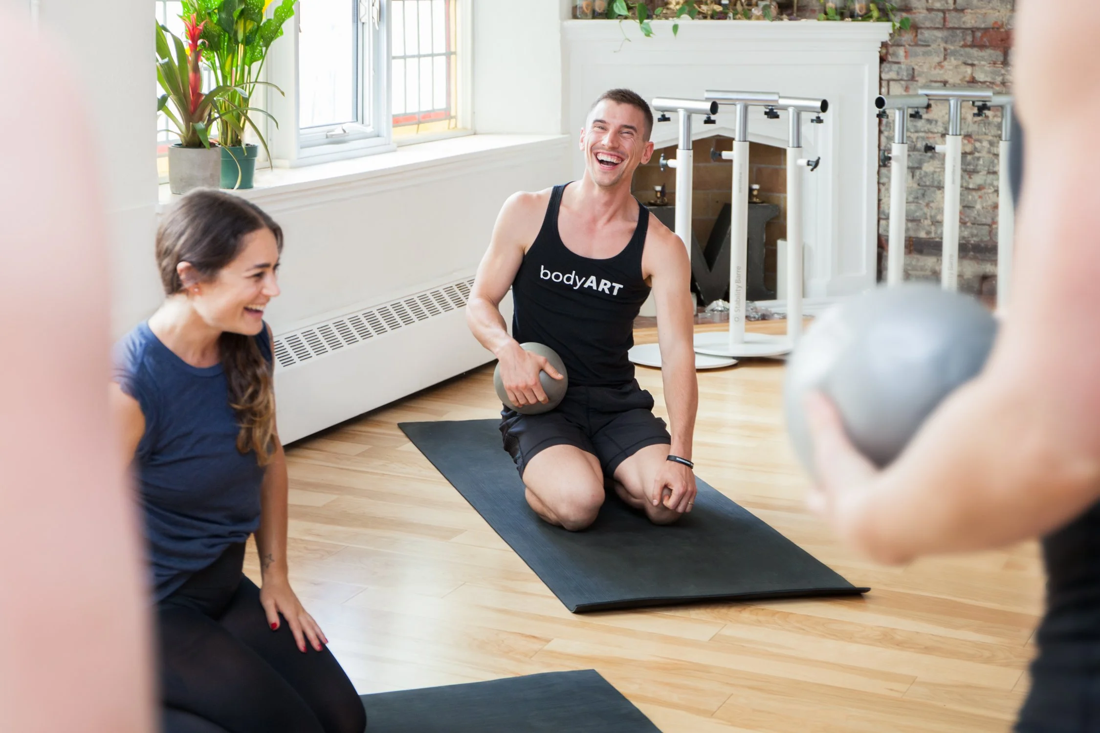 Fitness photography at Misfit studio with two models laughing by Toronto Lifestyle Photographer Joanna Wojewoda.