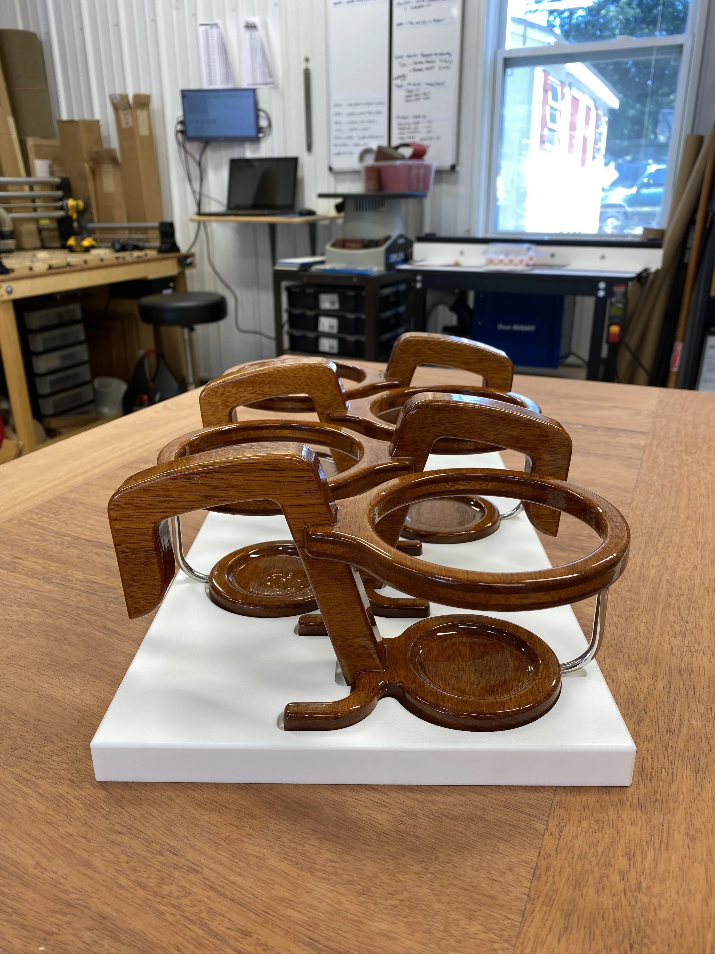 Mahogany cup holders designed to hang on a skiff's gunnel.