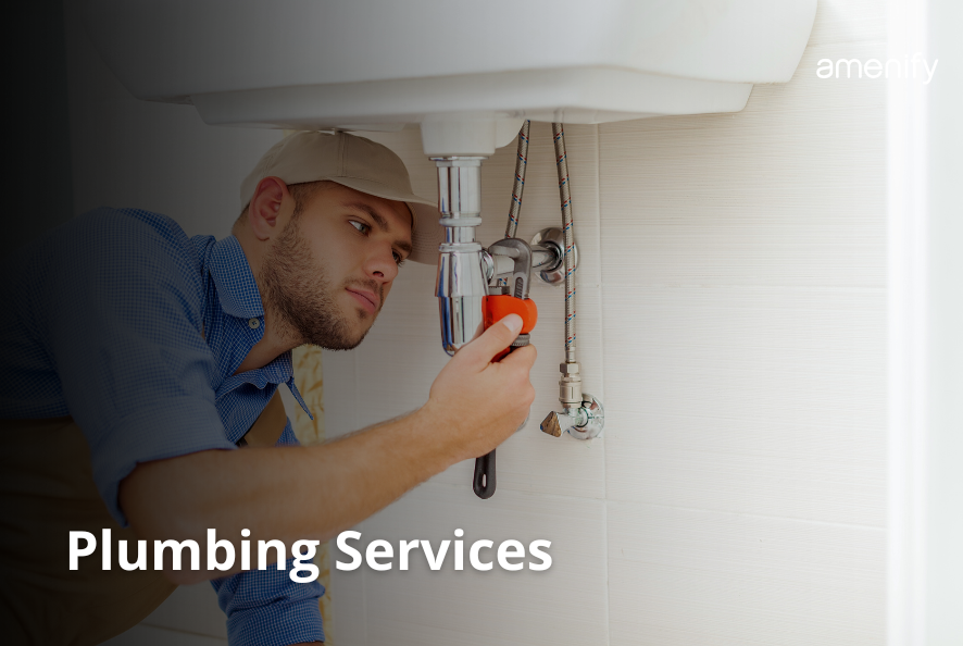 Handyman performing plumbing repairs on a kitchen faucet.
