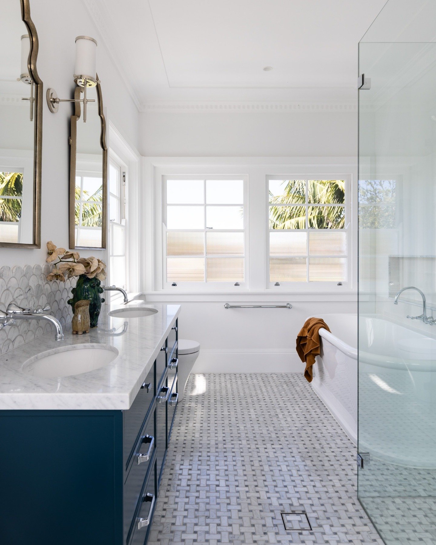 Previously an oversized media room, this first-floor space has been completely reimagined into a generous and light-filled family bathroom. 
With windows on three sides, privacy was a big consideration&mdash;but we made the most of the natural light 