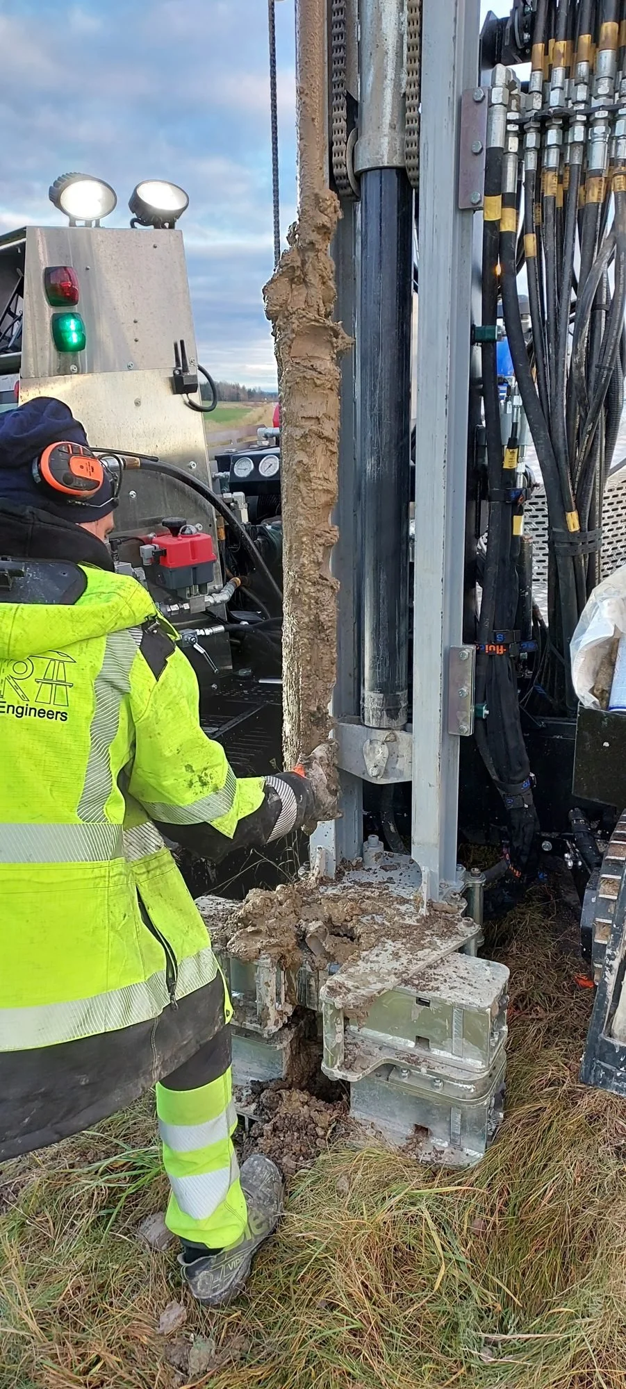 Fältgeotekniker i varselkläder arbetar vid borrigg