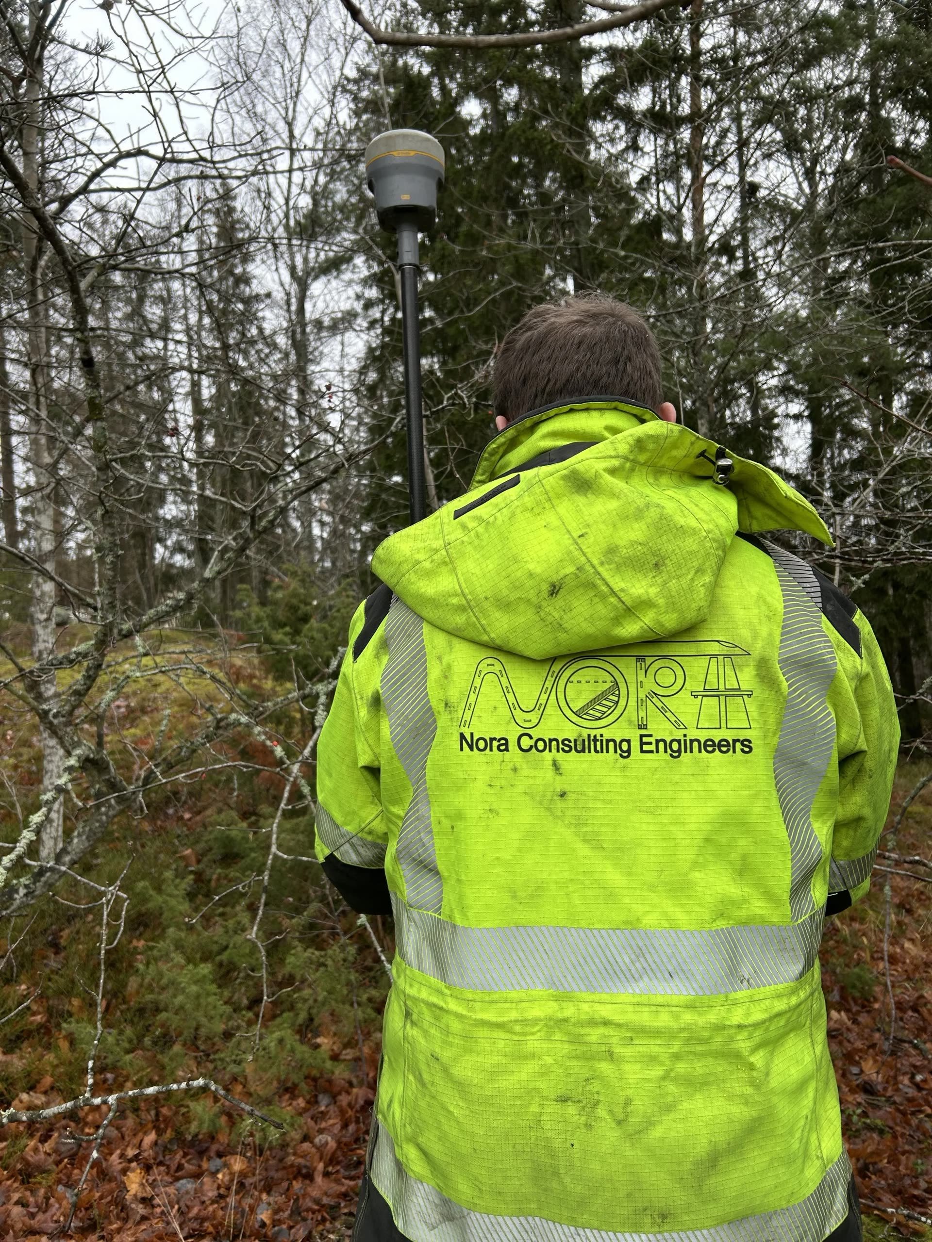 Fältpersonal i varselkläder vid markundersökning i skogsmiljö