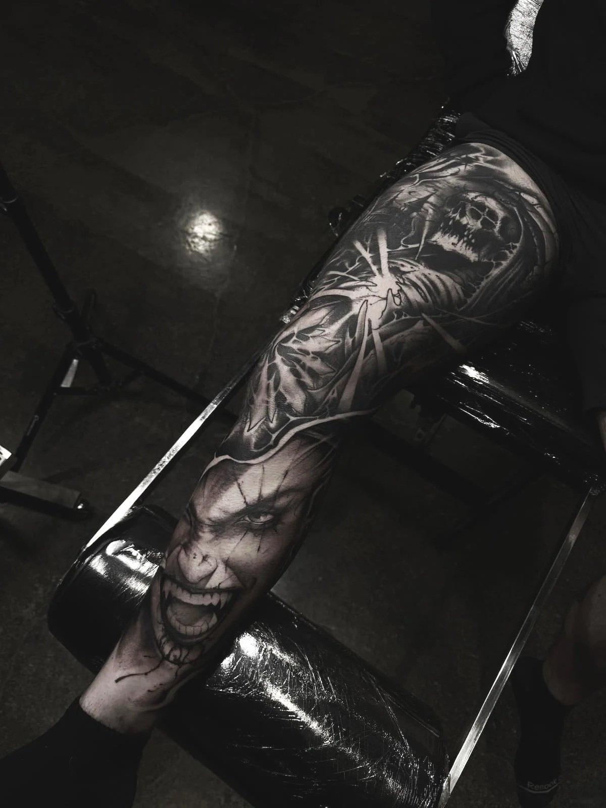 Custom black and grey horror leg tattoo with skull and dark realism imagery by an Austin tattoo artist.