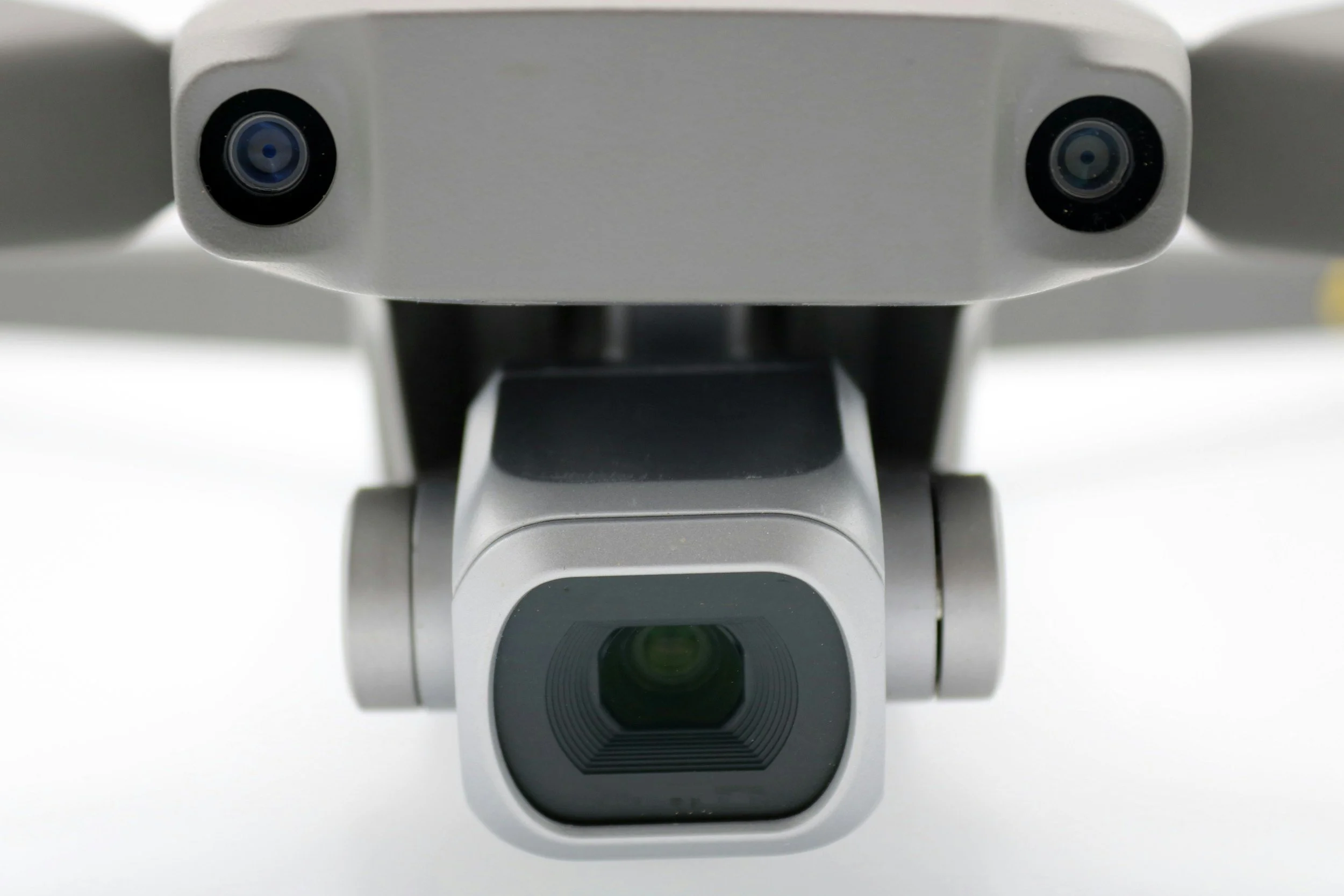 En nära bild av fronten på en drönare med två kameror, en på övre vänstra och en på övre högra sidan, samt en huvudsaklig kamera i mitten.