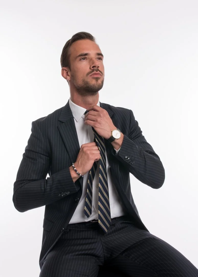 Man i kostym och slips justerar sin slips.