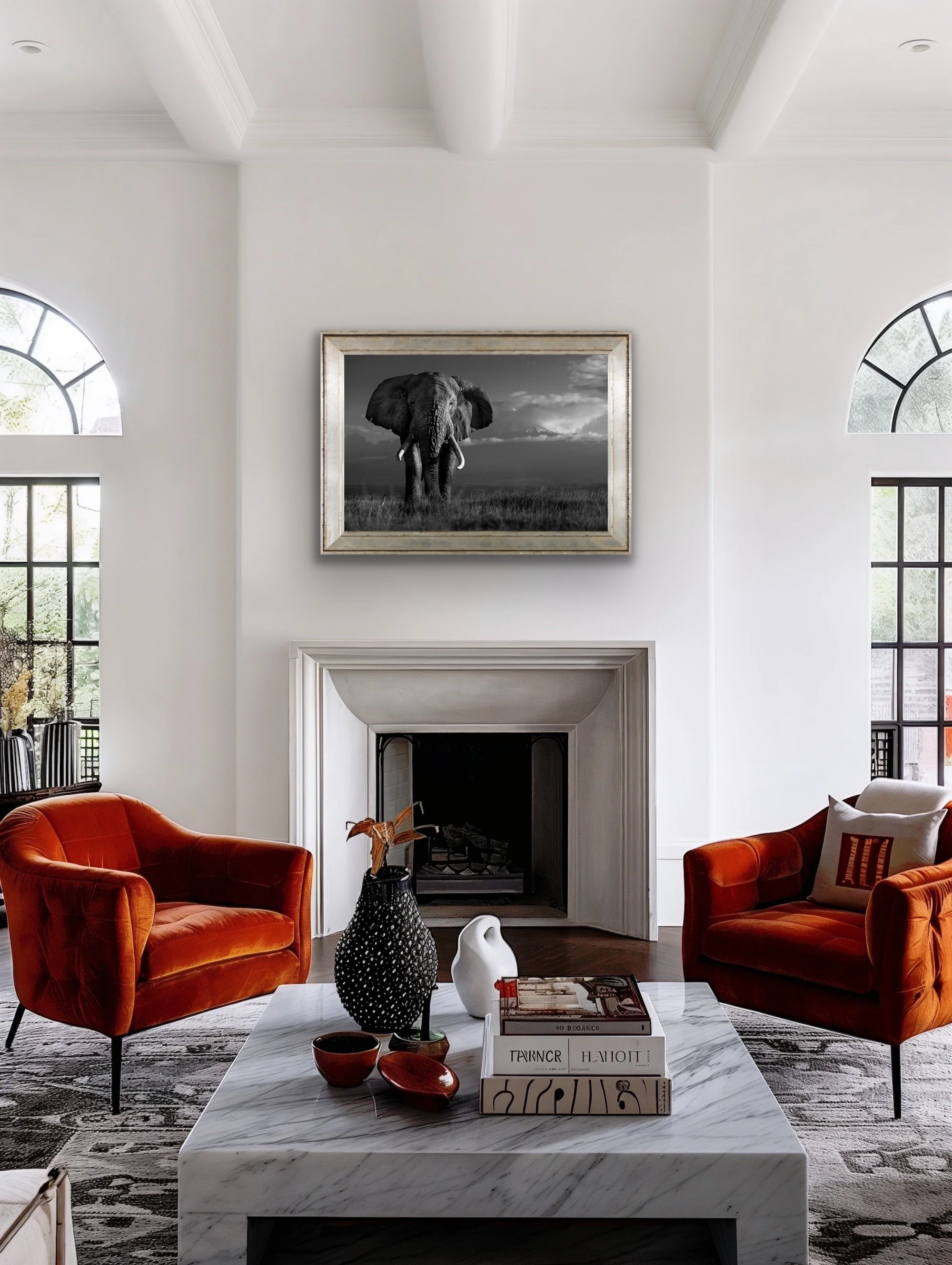 A cozy dining nook with a round wooden table, green upholstered chairs, and a built-in bench with cushions. A large framed photograph of a tiger on a grassy trail hangs on the wall.