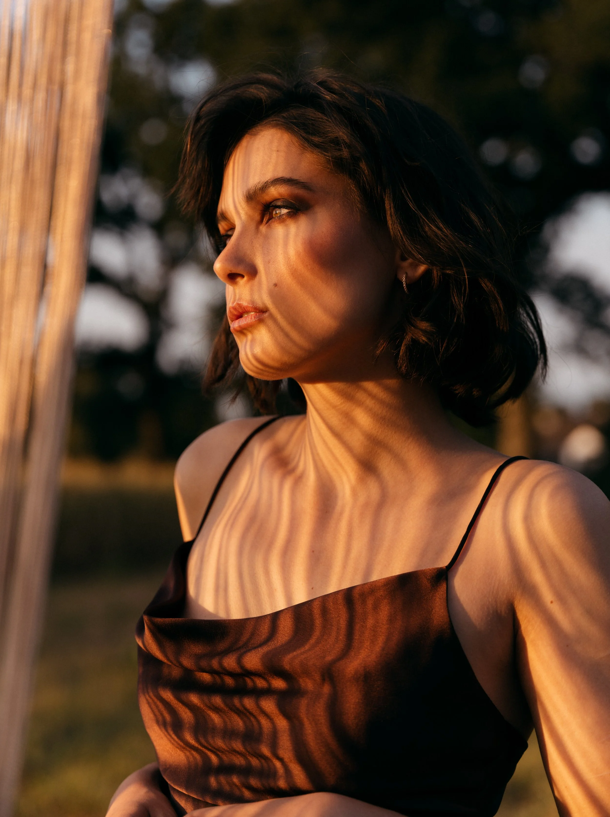 Model in a dress looking towards the sunset.