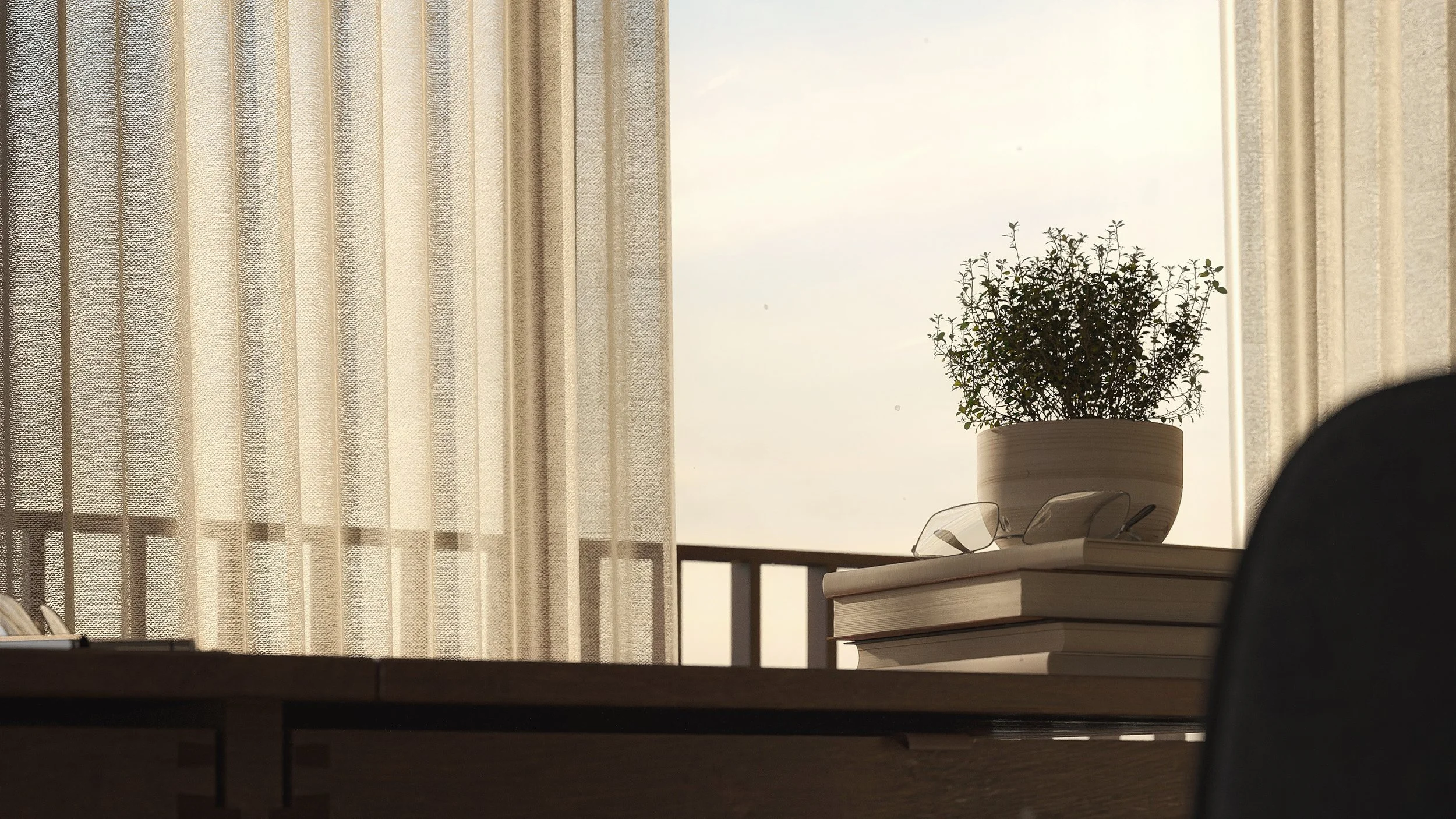 A potted plant on a stack of books on a wooden desk, near a window with sheer curtains, with a pair of glasses resting on the books.
