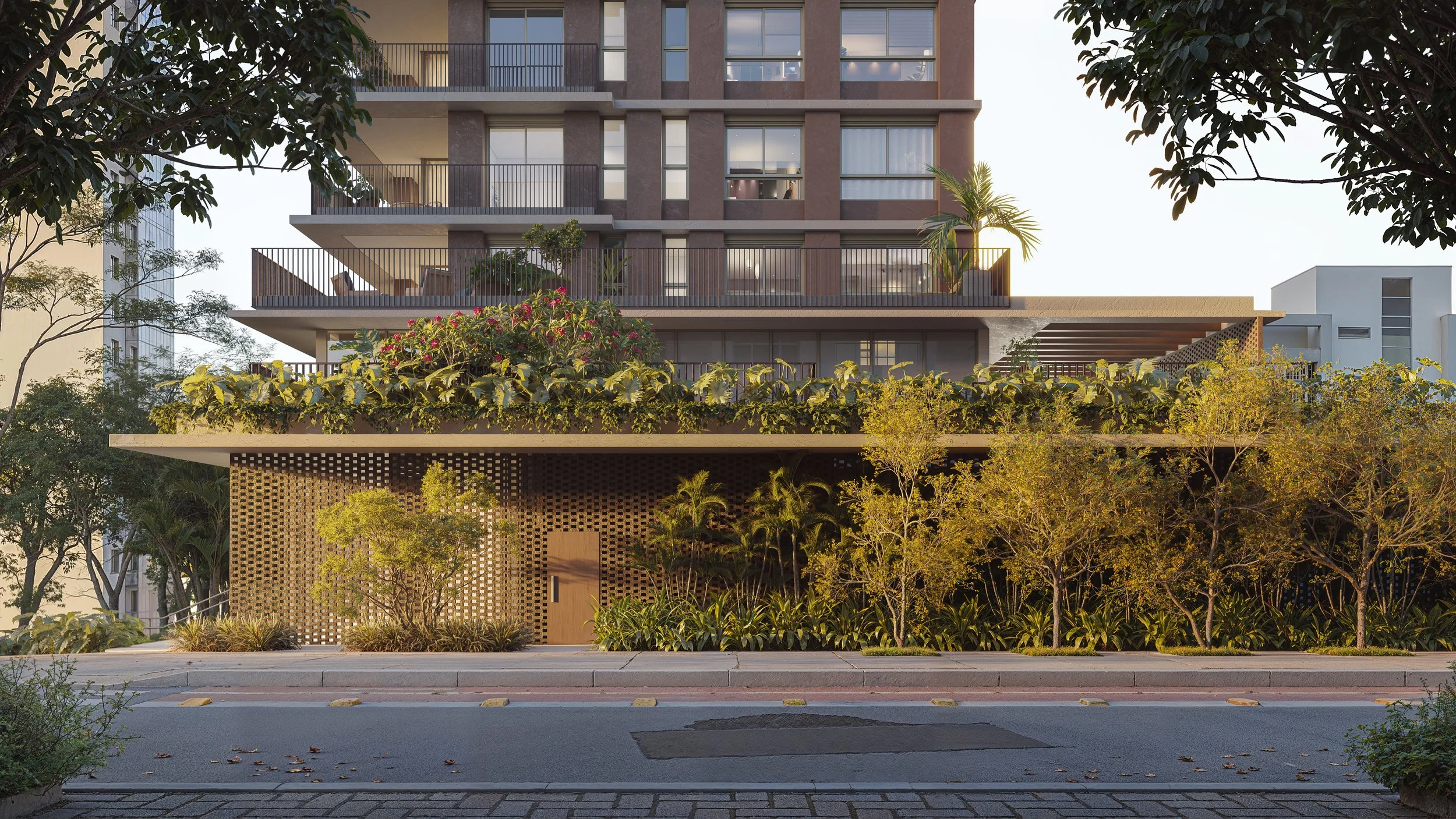 A modern multi-story residential building with balconies and large windows, surrounded by landscaped greenery and trees, with a sidewalk and street in the foreground.