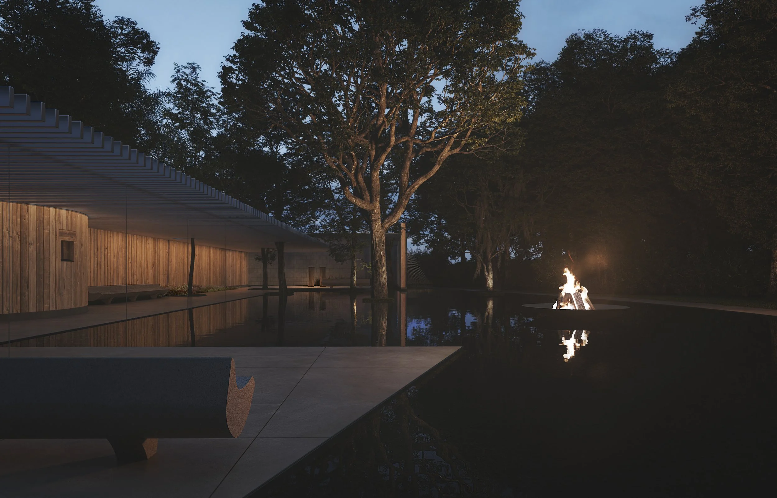 A modern outdoor space at dusk with a fire pit, trees, a building with wooden walls, and a reflecting pool.