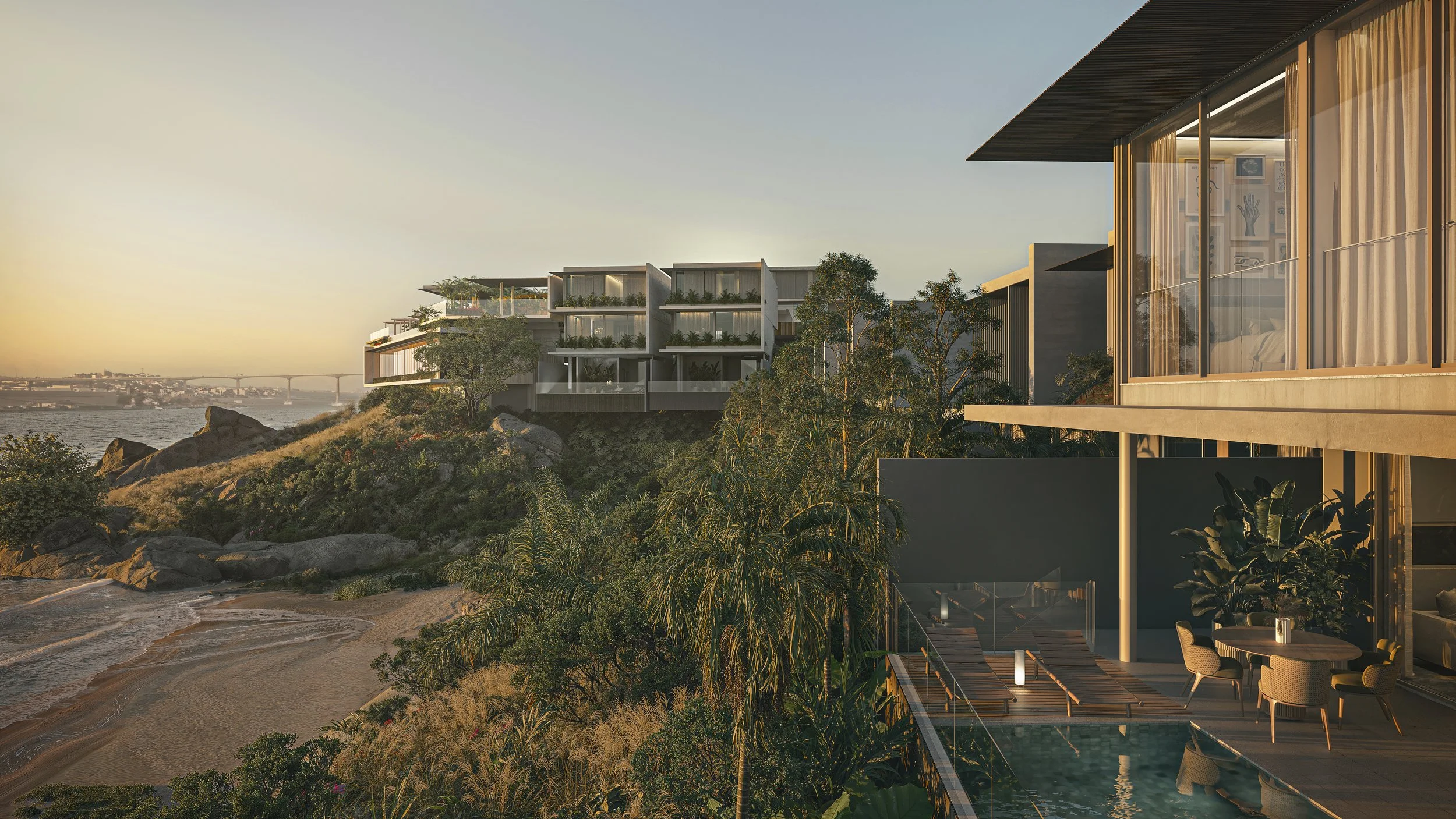 Luxury modern houses with large glass windows overlooking a rocky coastline and a river at sunset.