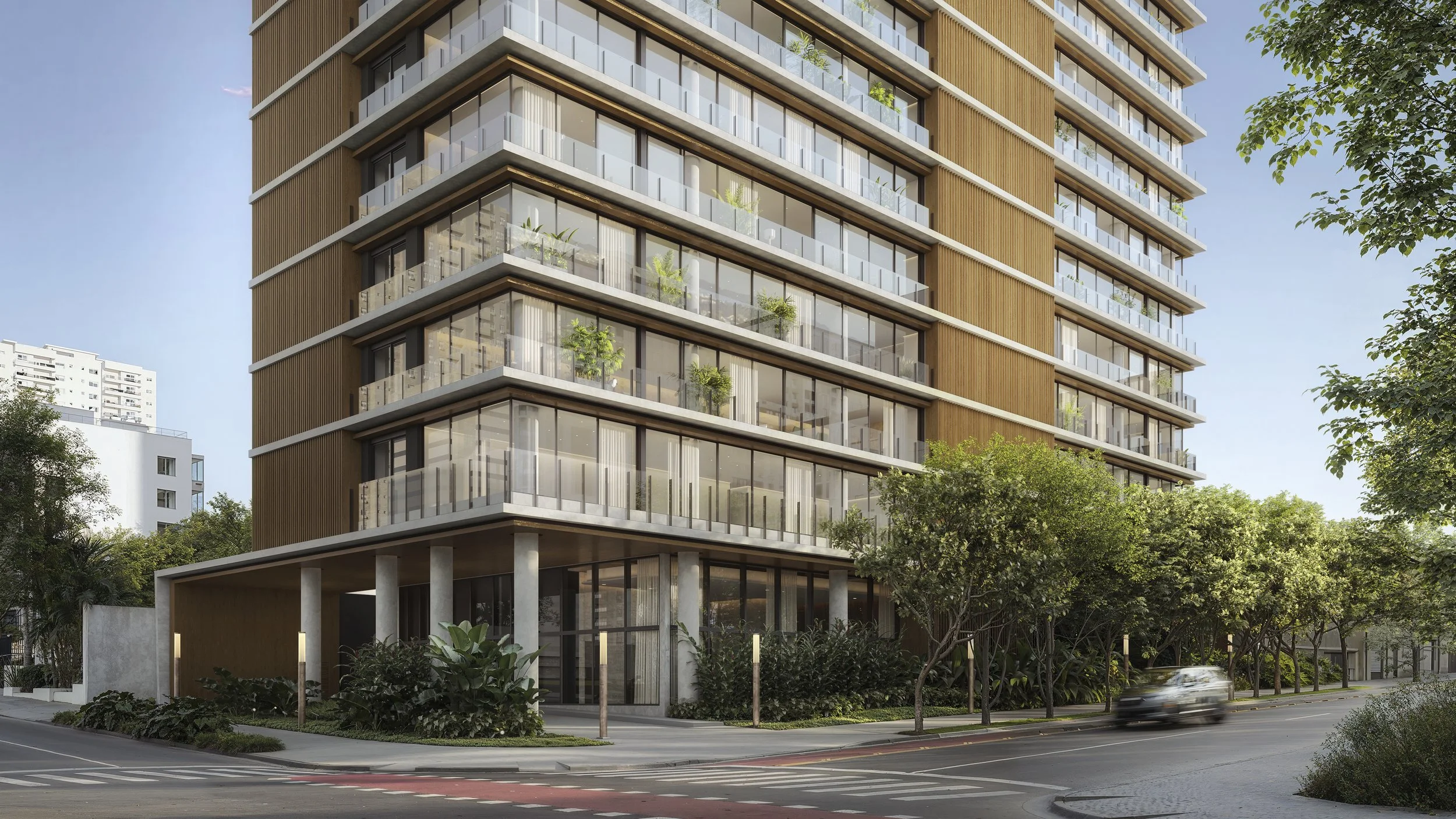 Modern multi-story residential building with glass balconies, surrounded by trees, with a street and parked car in front.