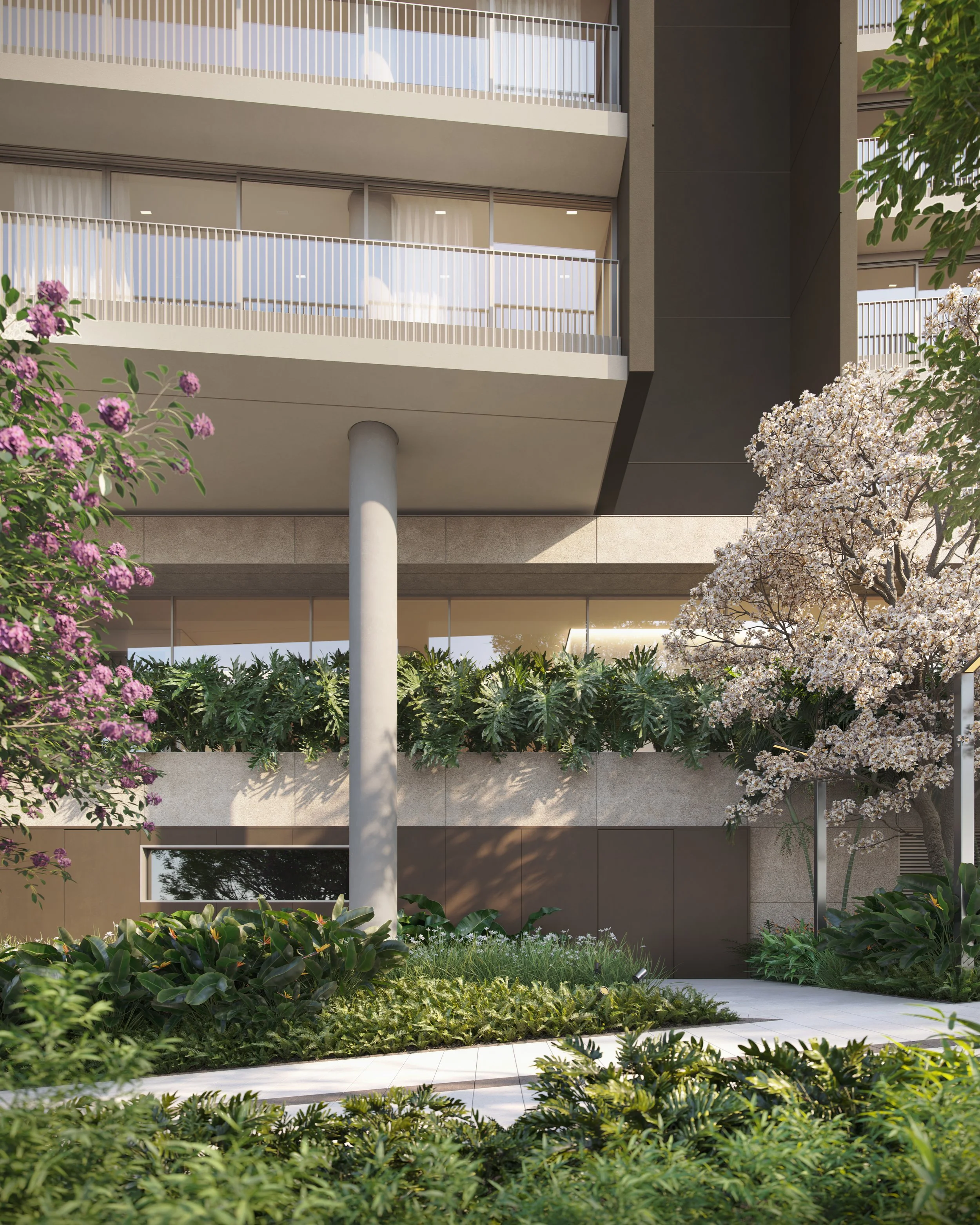 Modern apartment building with balconies, surrounded by lush green plants and flowering trees.