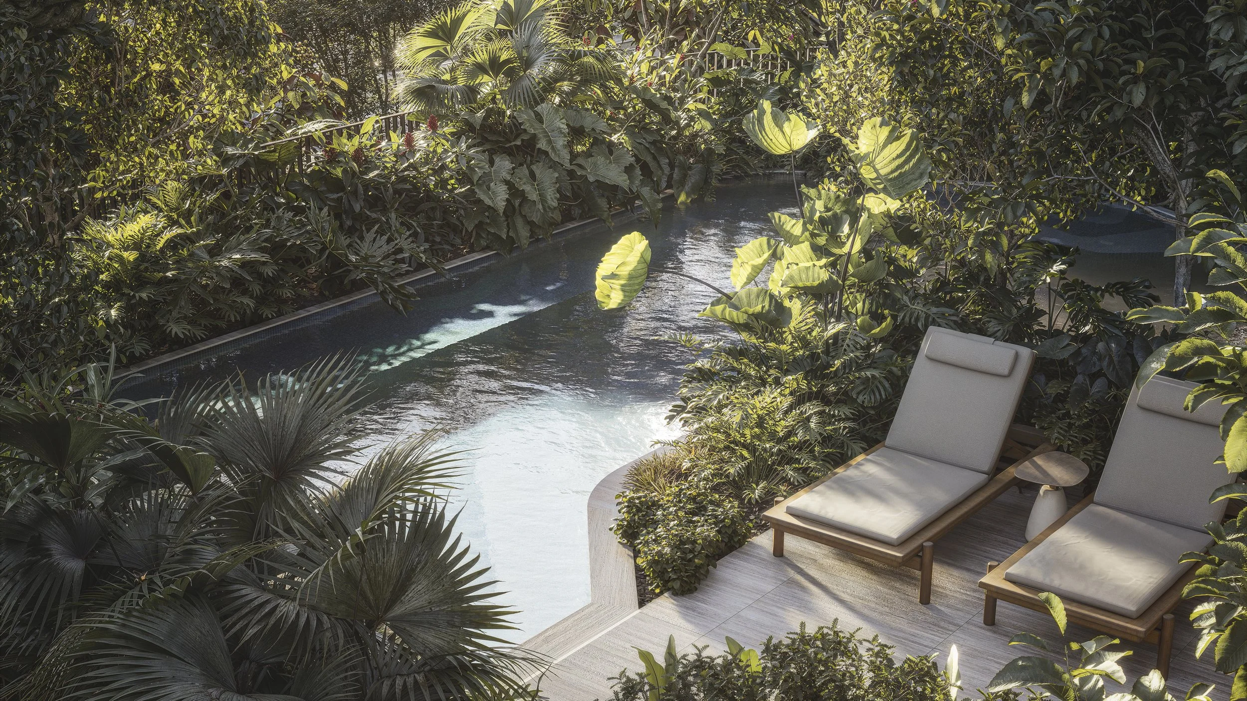 A small outdoor pool surrounded by lush green tropical plants and trees, with two beige lounge chairs on a light-colored tiled patio.