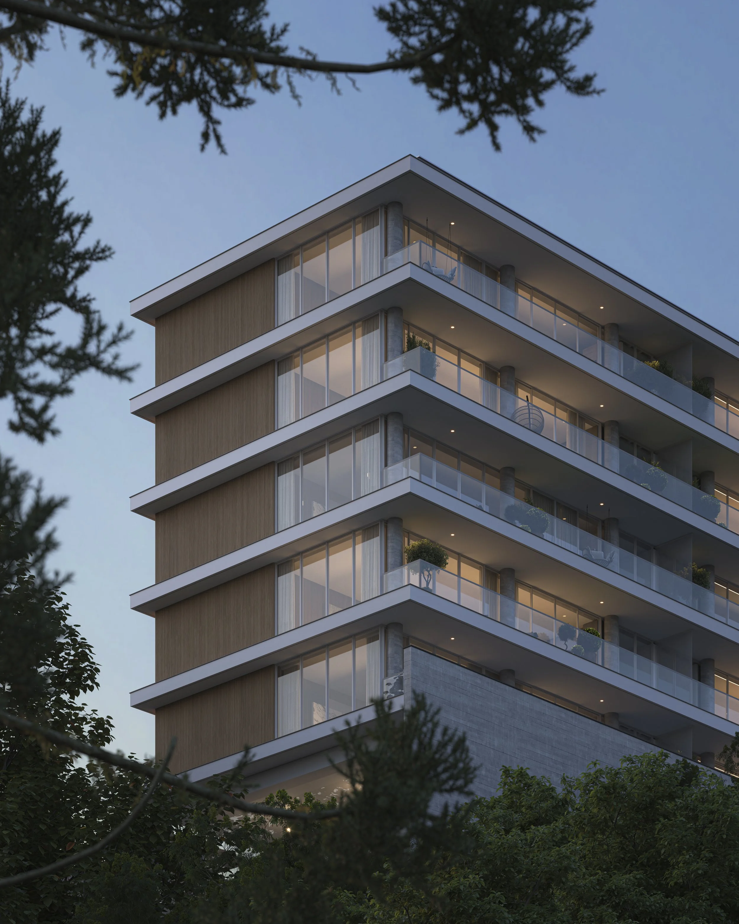 A modern multi-story apartment building with large glass balconies, surrounded by trees at dusk.