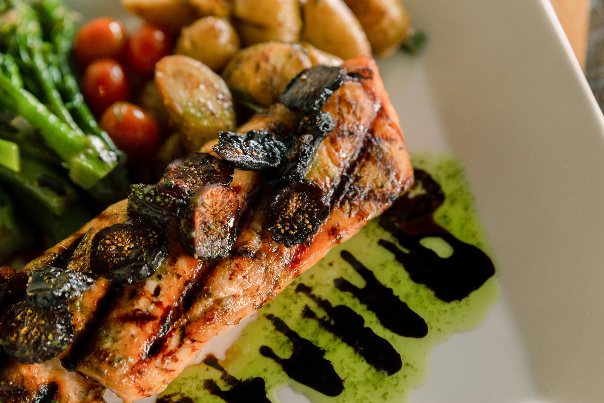 Marinated grilled salmon topped with figs & balsamic glaze. Served with rosemary roasted potatoes & sautéed seasonal veggies.