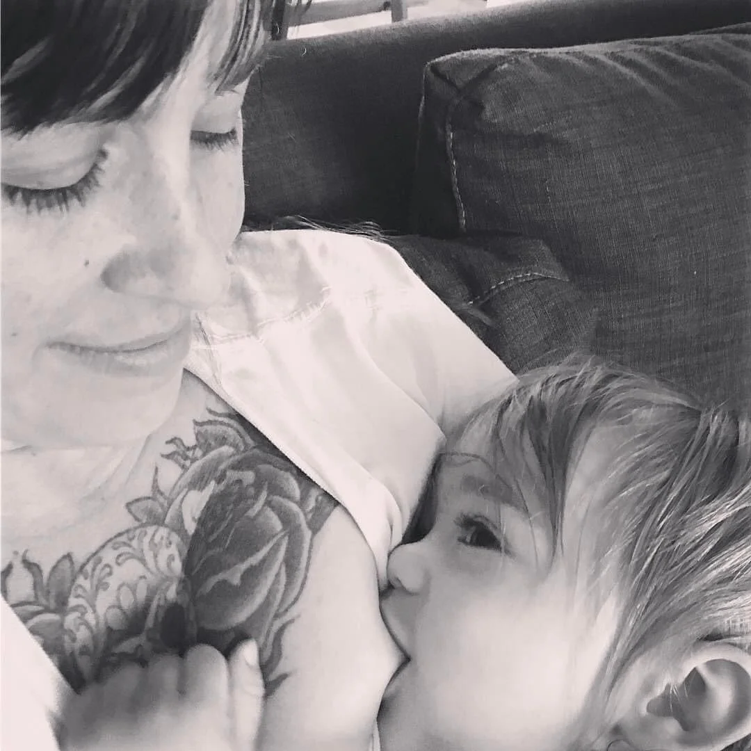birth doula breast feeding, body feeding, nursing baby. Momma who is a doula professional breastfeeding her baby, baby giving mama milky smiles, breastfeeding baby bonding, endorphins released during breastfeeding baby.