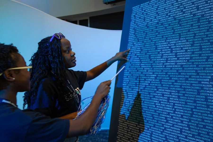 Summer U participants look for their name on the Summer U Class of 2026 board.