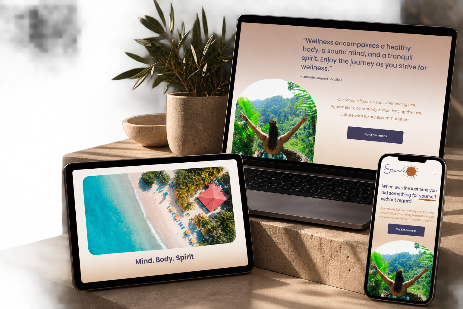 A laptop, tablet, and smartphone displaying wellness retreat information and scenic images on a stone surface, with potted plants nearby.