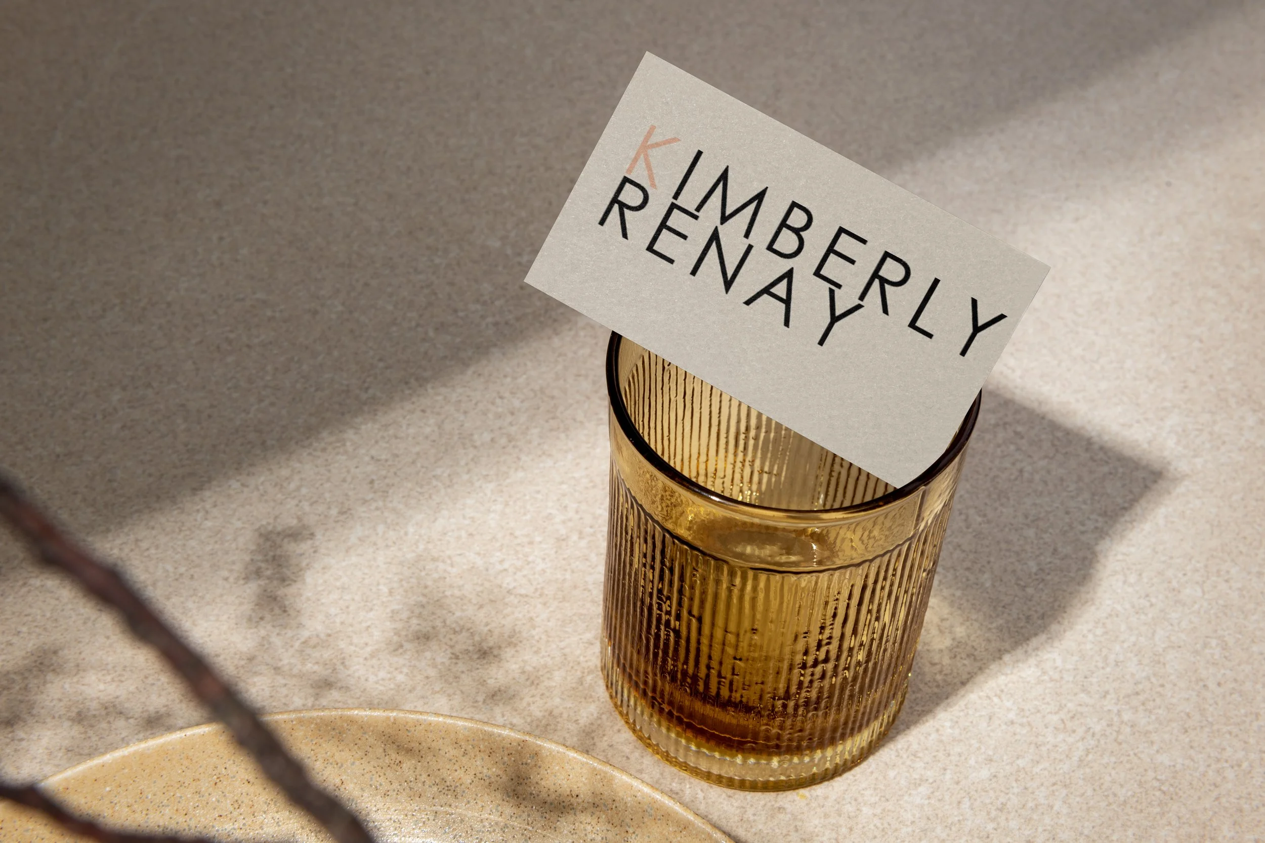 A glass with a textured gold surface holding a white piece of paper with black and peach text that reads 'I'M A BE RLY, REALLY.'