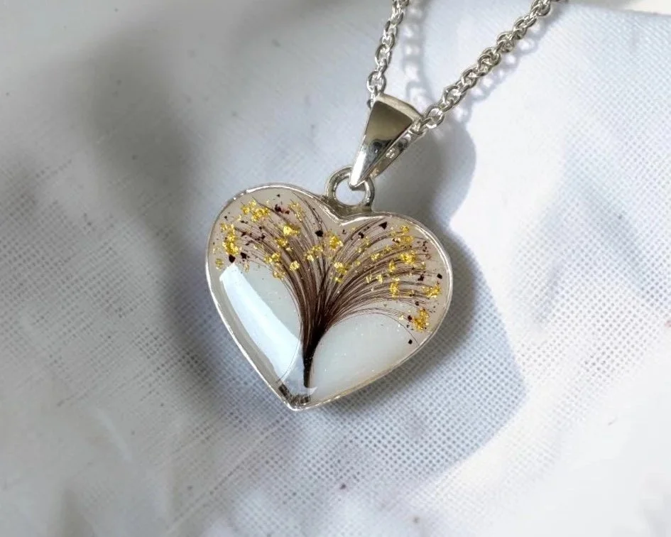 Heart-shaped breastmilk necklace containing gold flecks
