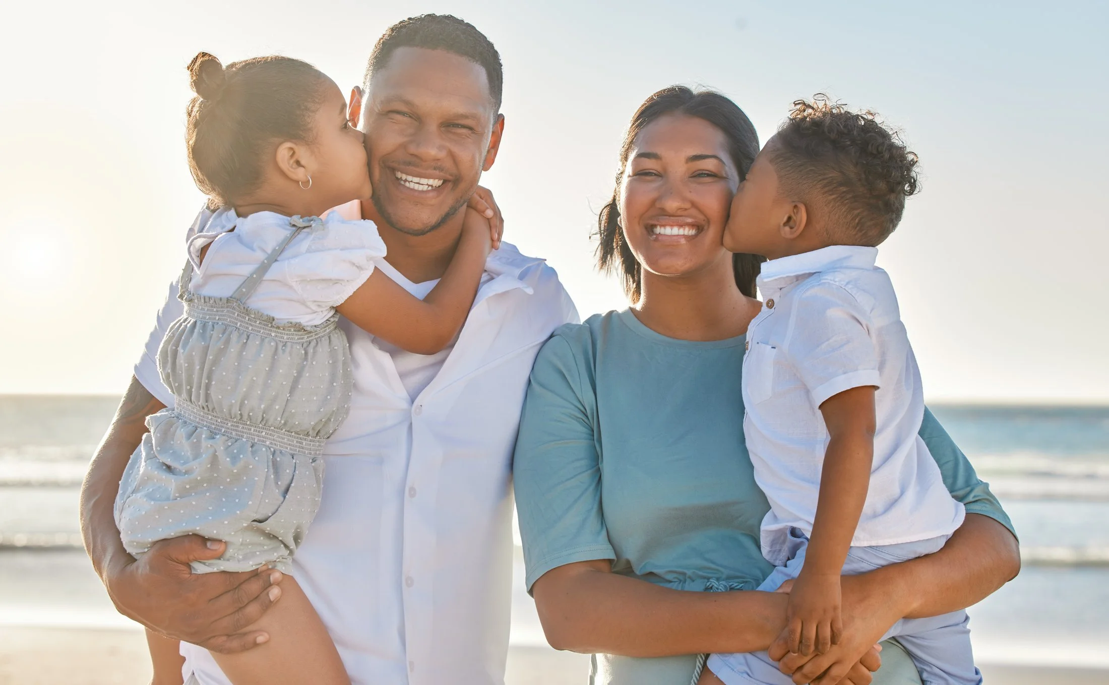 Happy family at the beach enjoying a vacation they can still afford even while enjoying the security of Protect Our family