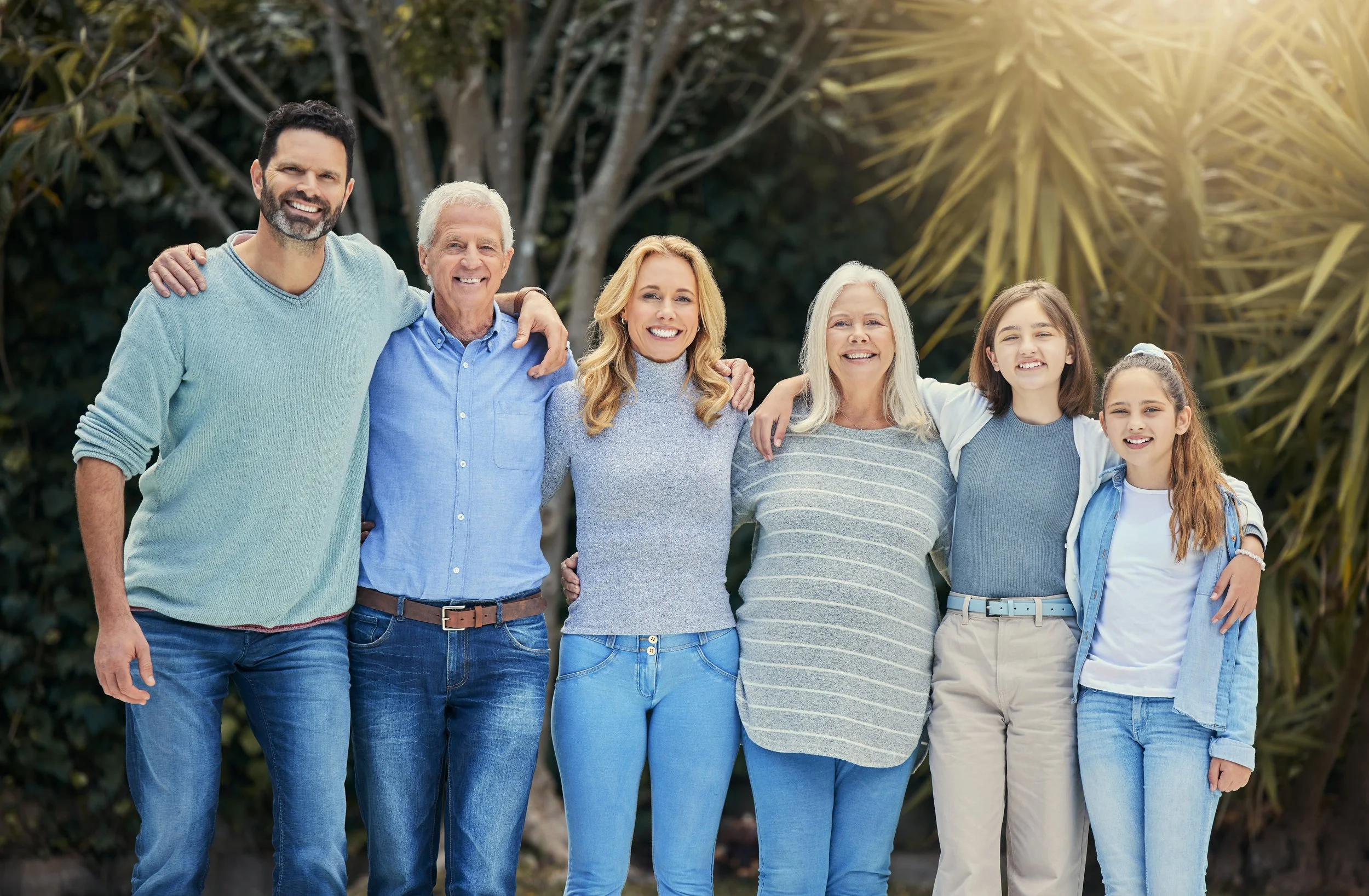 A family smiling together in a sunny garden. They have taken steps to keep their family safe and are ready in an emergency