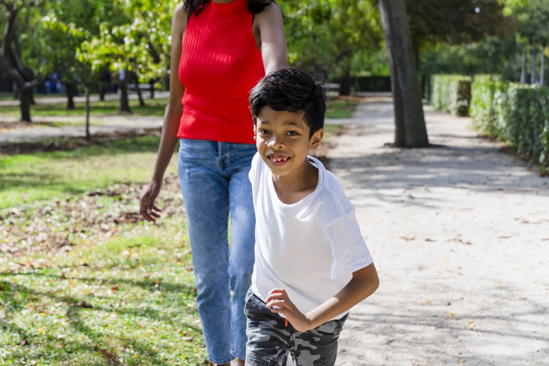 A caring adult and a child enjoying a happy moment together outdoors.