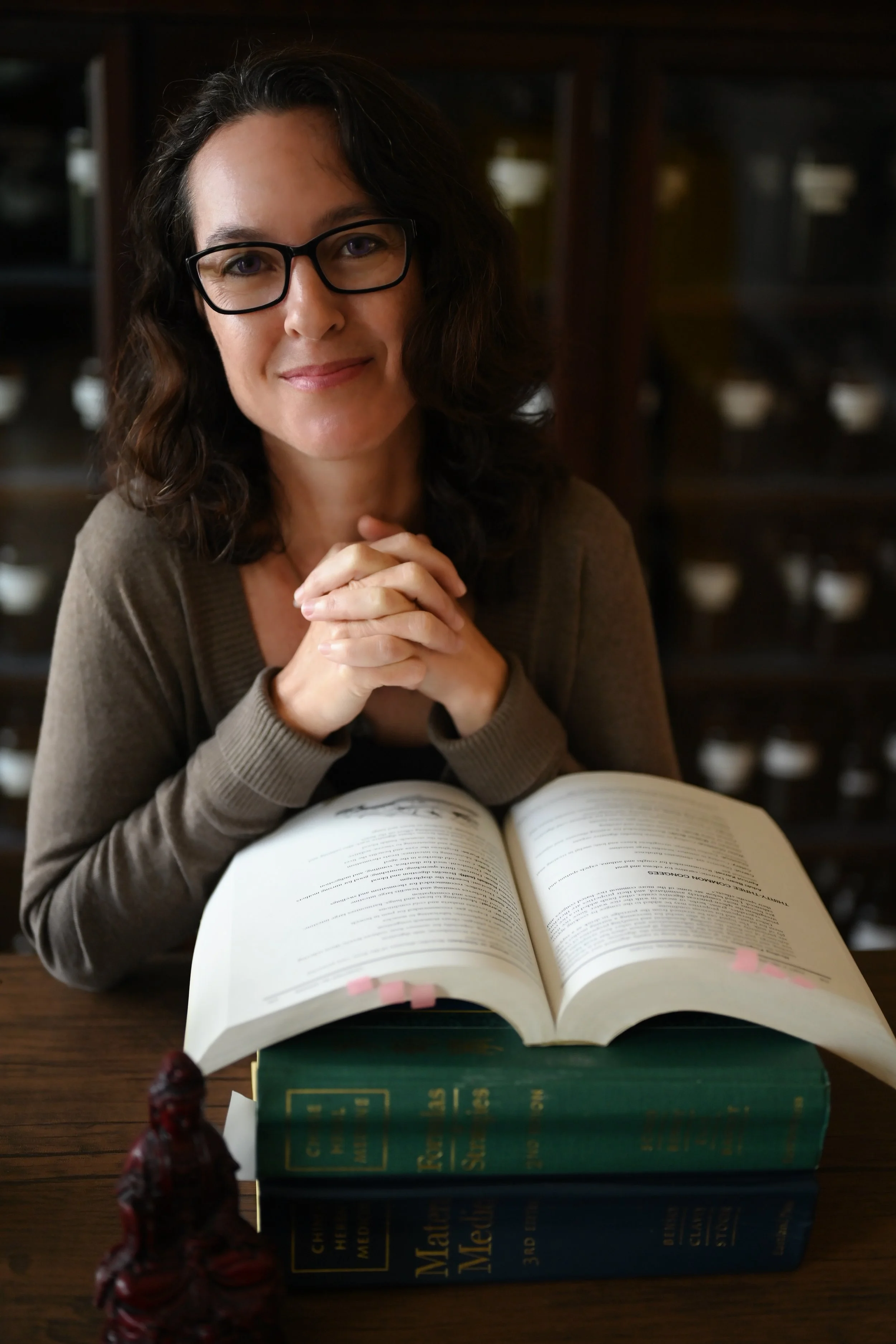 Herbal Medicine in San Marcos, CA - Herbalist sitting with books on Chinese Medicine in clinic.