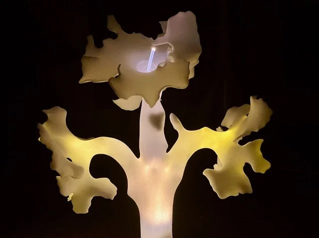 An artistic illustration of a tree with a light source behind it, creating a glowing effect.