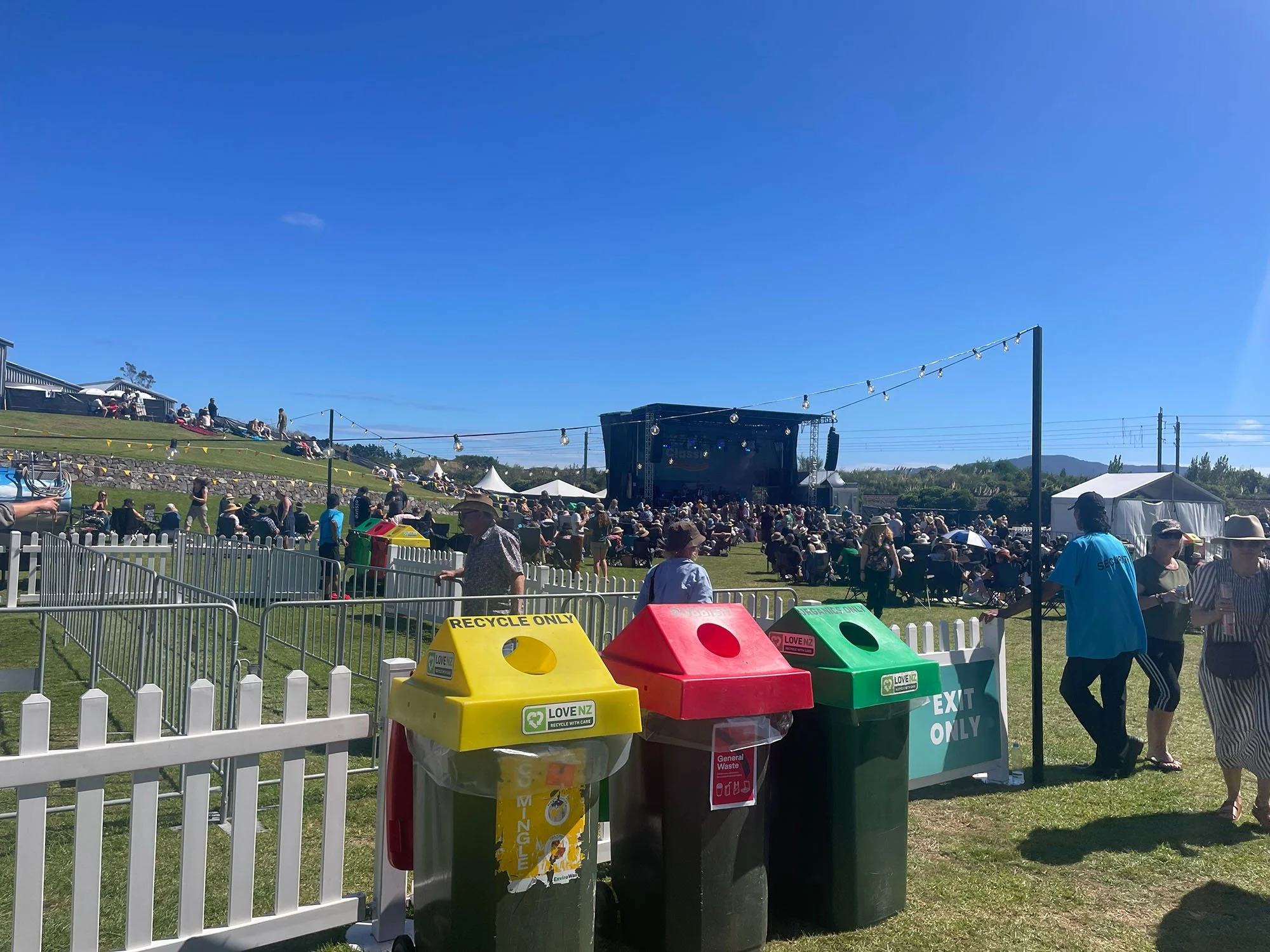 Colour-coded waste and recycling bins at Kāpiti Classic outdoor music festival.
